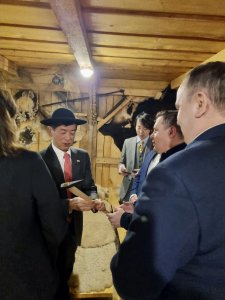 Burmistrz Tomasz Bujok wręcza ambasadorowi góralski kapelusz i obuszek