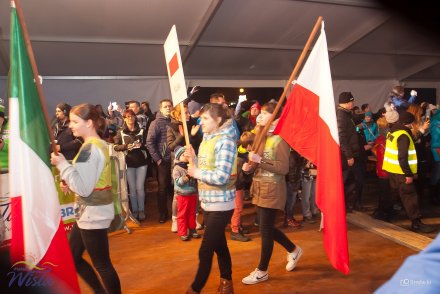 Wolontariusze z flagami podczas ceremonii wręczenie numerów startowych