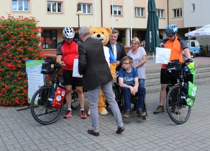 Asystent burmistrza wręcza upominki dla rowerzystów i Dawida