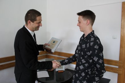 Paweł Wąsek odbiera statuetkę od przewodniczącego Rady Miasta